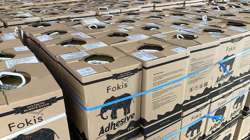 Top-side view of numerous carton-packed Fokis Adhesive boxes.