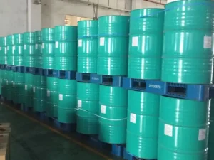 Fokis shoe adhesive stored in green large steel drums, neatly arranged on blue pallets.
